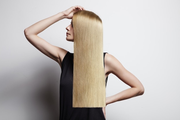 Blonde Frau, die ideales Haar zeigt