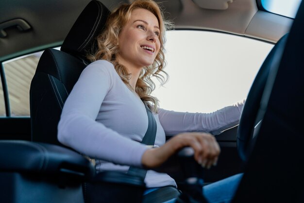 Blonde Frau, die ihr Auto fährt