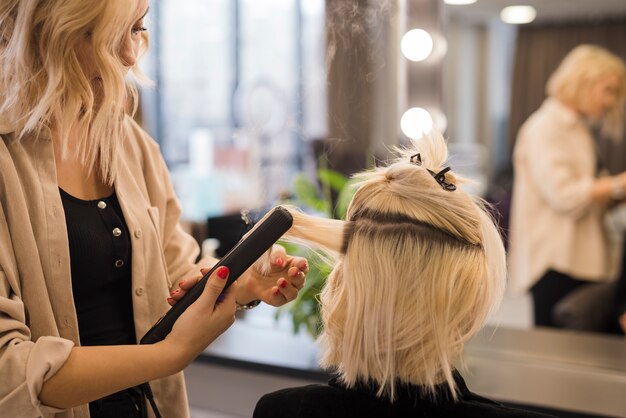 Blonde Frau, die ihr Haar erledigt bekommt