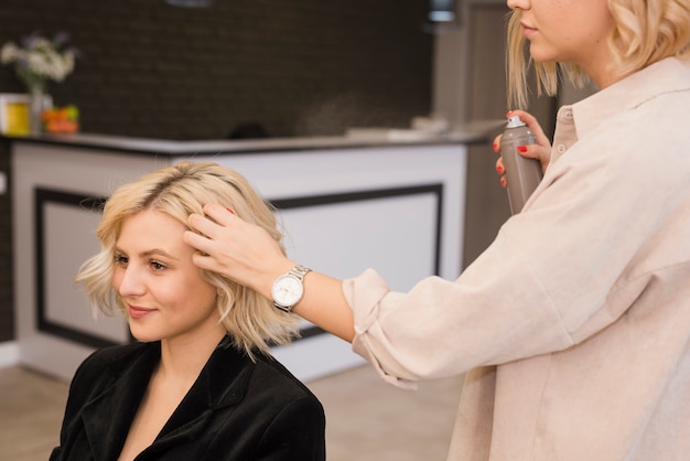 Blonde Frau, die ihr Haar erledigt bekommt