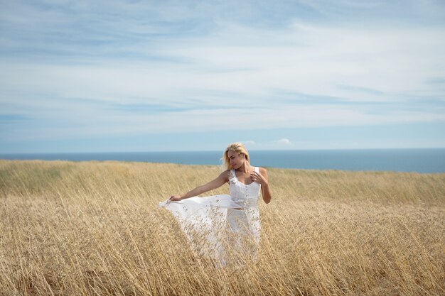 Blonde Frau, die im Feld steht