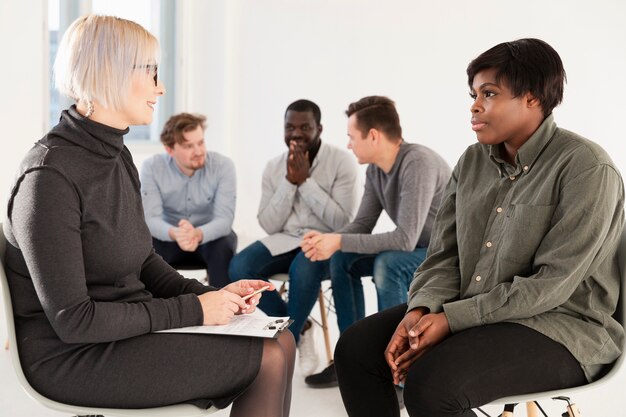 Blonde Frau, die mit weiblichem Rehabilitationspatienten spricht