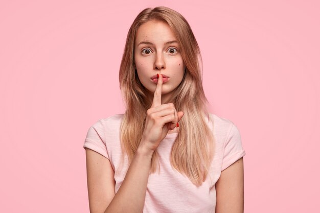 Blonde Frau, die rosa T-Shirt trägt