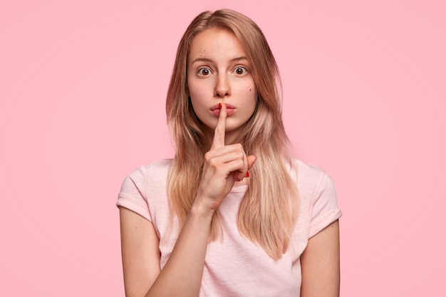 Blonde Frau, die rosa T-Shirt trägt