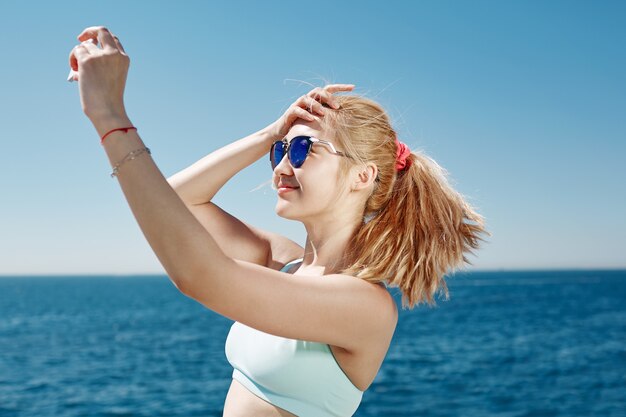 Blonde Frau, die selfie am Strand nimmt