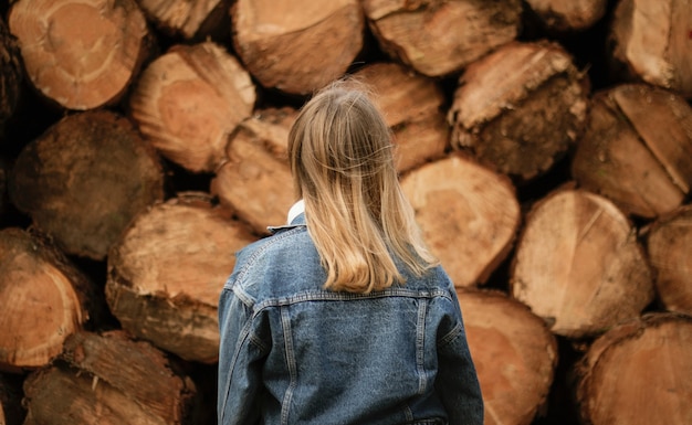 Blonde Frau, die während des Tages nahe Holz steht