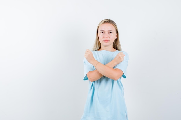 Blonde frau, die zwei arme verschränkt hält und kein zeichen gestikuliert