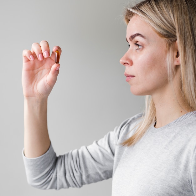 Kostenloses Foto blonde frau hält pille