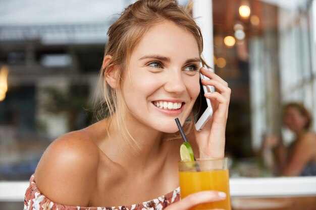 Blonde Frau im Blumenkleid im Café