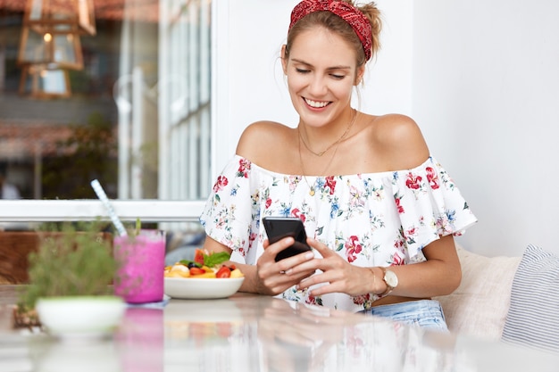 Blonde Frau im Blumenkleid im Café