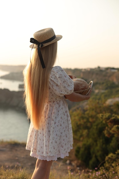 blonde Frau in der Nähe der schönen Rückseite mit Meerblick