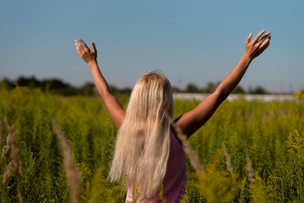 Blonde Frau mit ihren Armen in der Luft