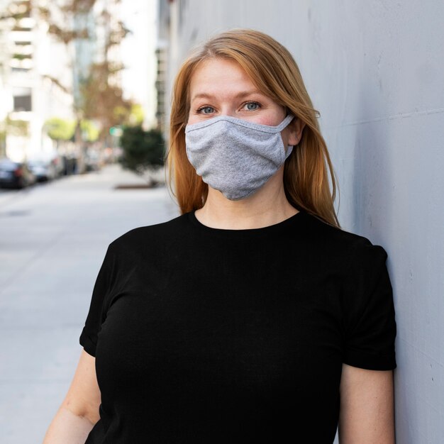 Blonde Frau mit Maske in der Stadt Outdoor-Fotoshooting