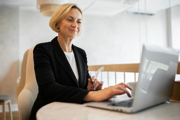 Blonde Geschäftsfrau, die an ihrem Laptop arbeitet