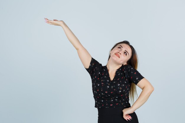 Blonde junge Dame im Kleid gestikuliert isoliert