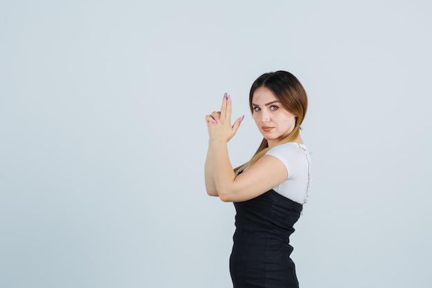 Blonde junge Dame im Kleid gestikuliert isoliert