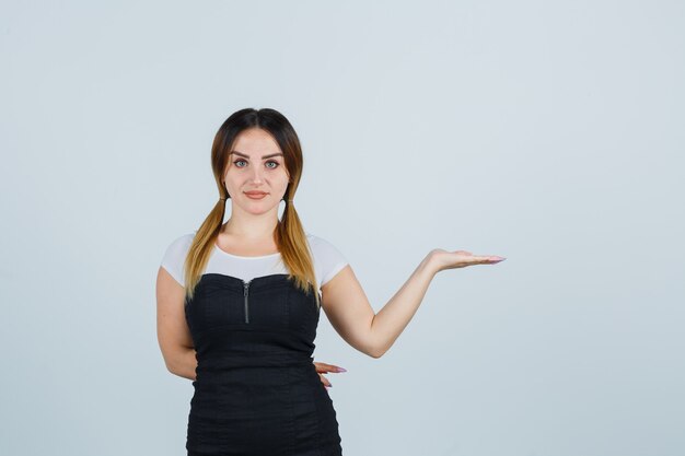 Blonde junge Dame im Kleid gestikuliert isoliert