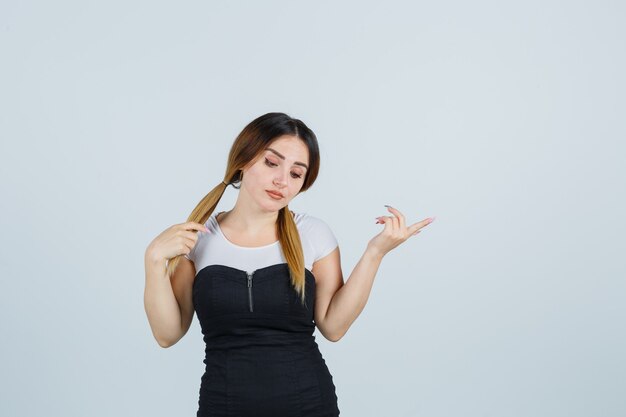 Blonde junge Dame im Kleid gestikuliert isoliert