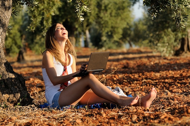 Blonde Mädchen mit ihrem Laptop lachen