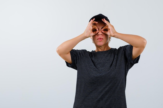 Blonde reife Frau in einem schwarzen T-Shirt und einer schwarzen Mütze