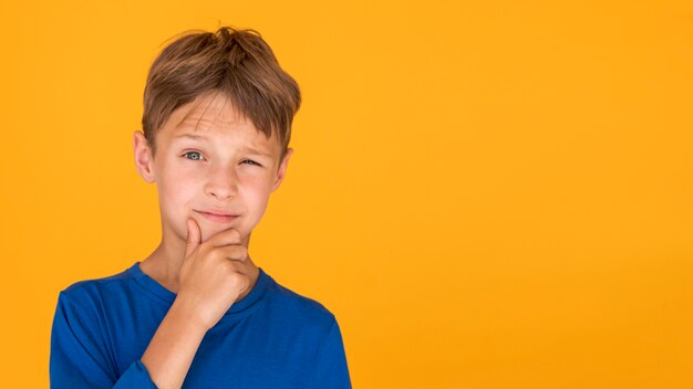 Blonder Junge, der mit Kopienraum bezaubert