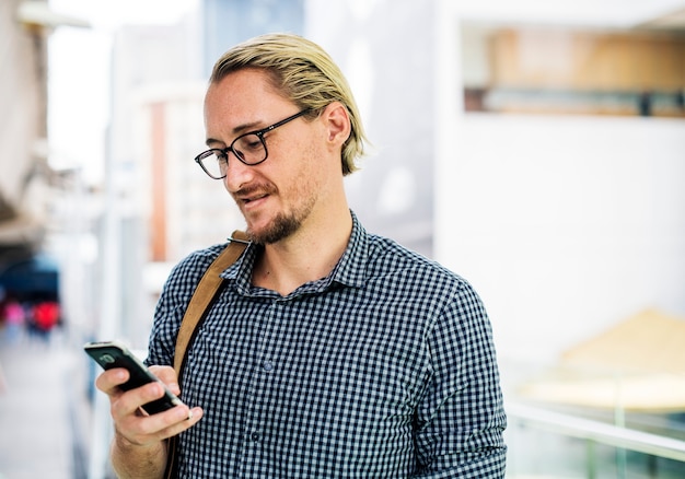 Kostenloses Foto blonder mann, der an seinem telefon simst