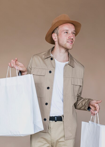 Blonder Mann, der Einkaufstaschen hält