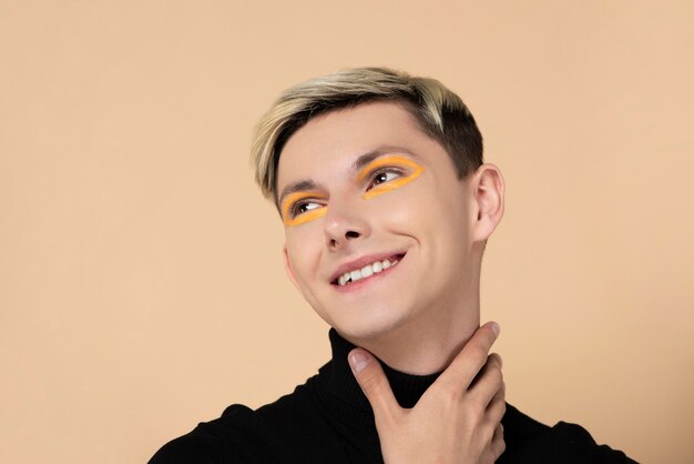 Blonder Mann, der orange Eyeliner trägt