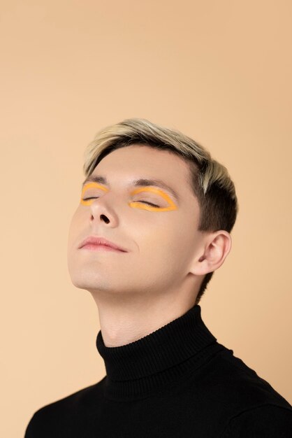 Blonder Mann, der orange Eyeliner trägt