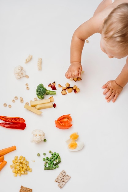 Kostenloses Foto blondes baby der draufsicht, das wählt, was zu essen