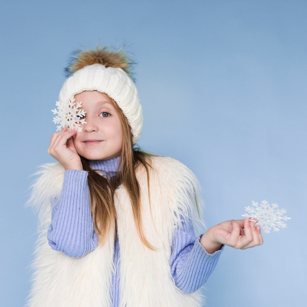 Blondes kleines Mädchen, das Schneeflocken hält