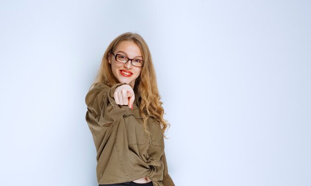 Blondes Mädchen, das die Person vor sich bemerkt und zeigt.