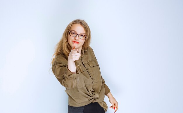 Blondes Mädchen, das die Person vor sich bemerkt und zeigt.