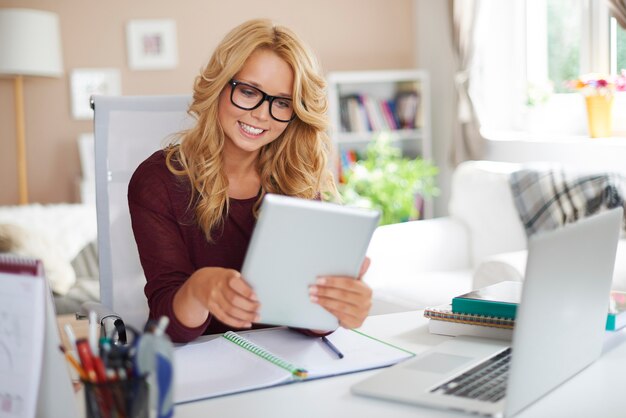 Blondes Mädchen, das durch neue Technologie zu Hause lernt