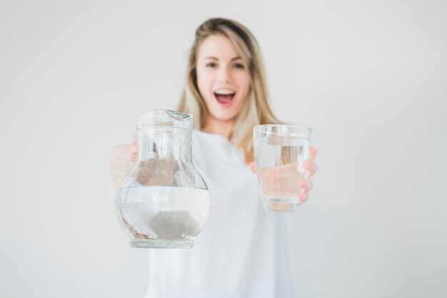 Blondes Mädchen, das Glas und Glas Wasser hält