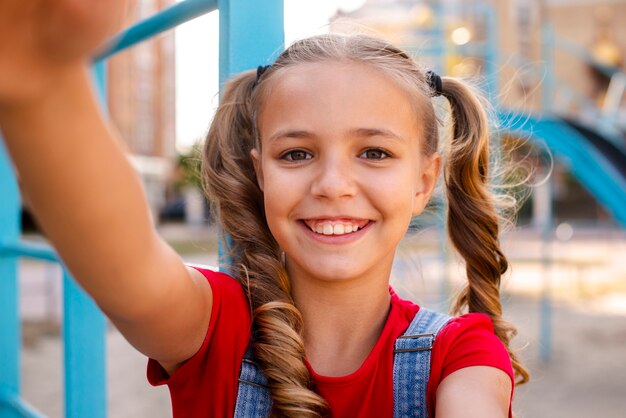 Blondes Mädchen, das heraus ihre Hände zur Kamera ausdehnt