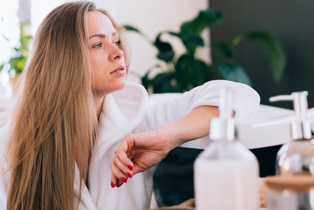 Blondes Mädchen, das im Badezimmer fertig wird