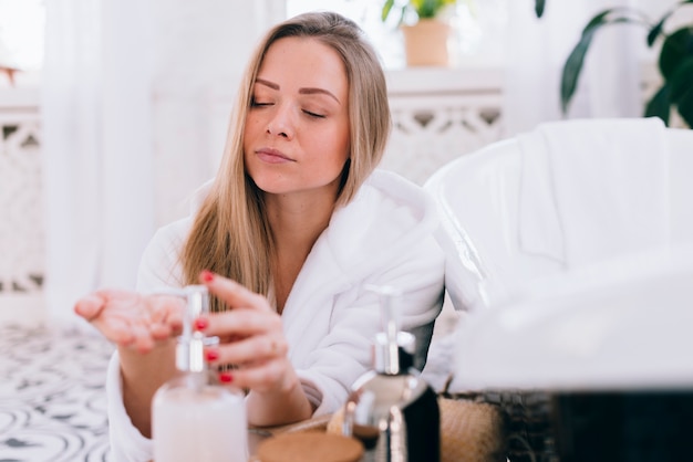 Blondes Mädchen, das Seife im Badezimmer verwendet