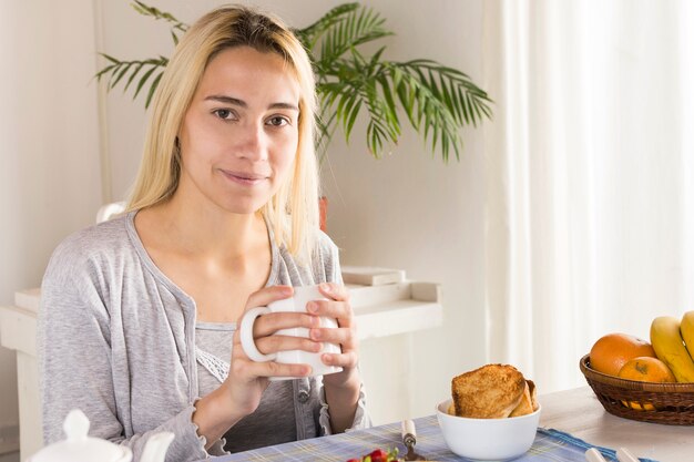 Blondes Mädchen, das Tee trinkt