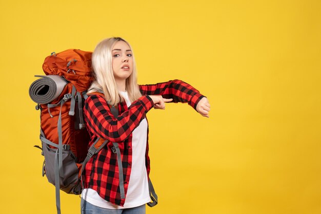 Blondes Mädchen der Vorderansicht mit ihrem Rucksack, der Zeit fragt