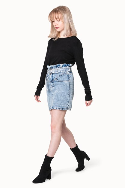 Blondes Mädchen in schwarzem Pullover und Jeansrock für Winterbekleidungsshooting