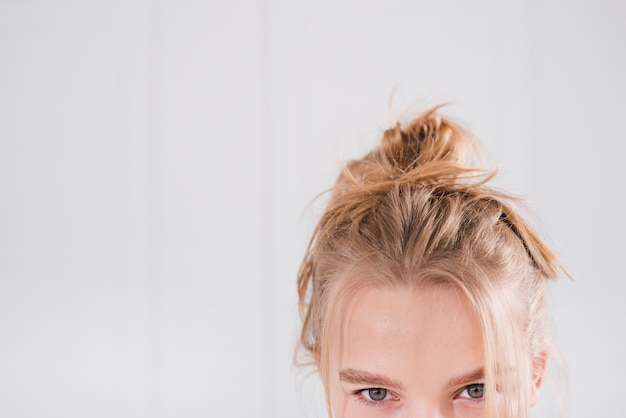 Blondes Mädchen mit unordentlichem Brötchen