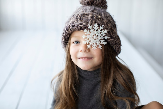 Kostenloses Foto blondes mädchen mit wintermütze und einer schneeflocke