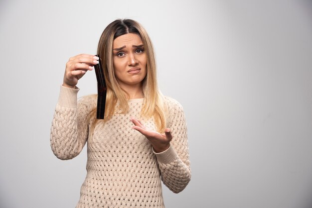 Blondes Mädchen prüft Fotos auf Fotorolle und fühlt sich enttäuscht.