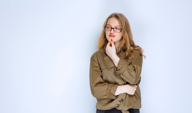 Blondes Mädchen sieht nachdenklich und zweifelnd aus.