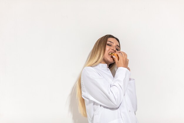 Blondes Model beißt ein Sandwich und genießt.