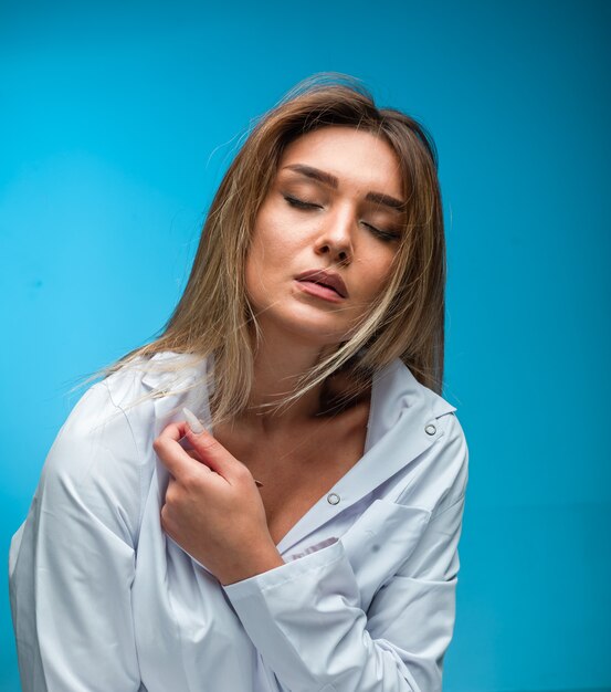 Blondes Modell im weißen Hemd sieht verführerisch aus.