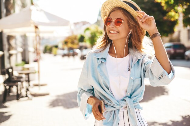 blondes Modell in Sommerkleidung, die auf der Straße aufwirft