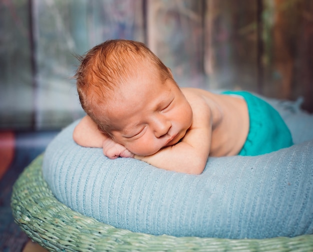 Kostenloses Foto blondes neugeborenes baby schläft auf weichem blauem kissen