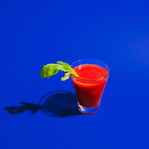 Bloody mary glas isoliert auf hellblauem neonhintergrund. geschmackskonzept, alkoholische getränke Premium Fotos